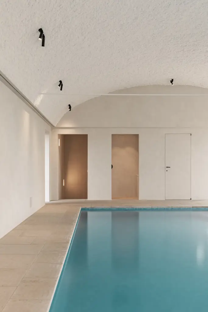Zwembad onder tongewelf met microcement deuren aan het einde, Schuur in Westkapelle, interieur Laura Calleeuw