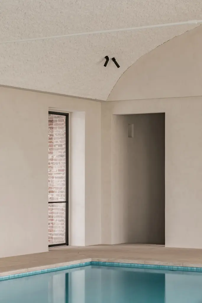 Zwembad met stalen venster met baksteen en nis in de wand, Schuur in Westkapelle, interieur Laura Calleeuw