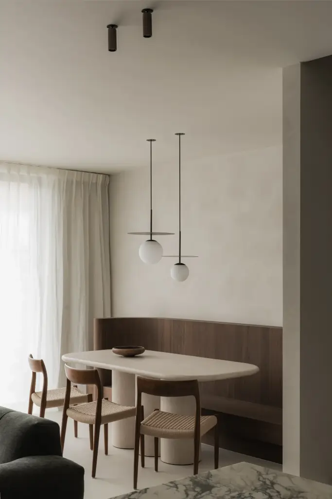 Eethoek met ovale tafel, stoelen, houten zitbank en twee hanglampen, Het Zoute Schorre, interieur Laura Calleeuw
