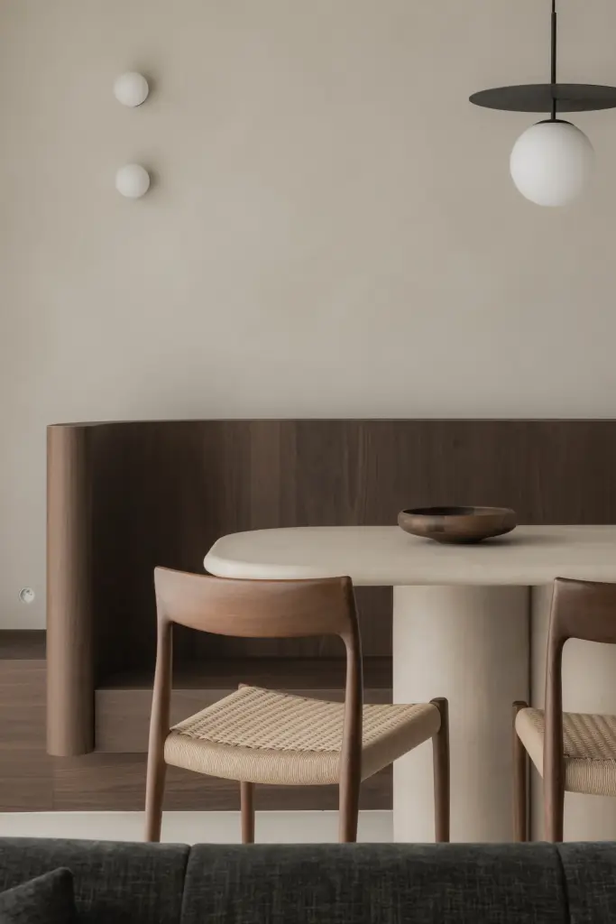 Gebogen houten zitbank met ovale tafel, bolvormige wandlampen en een hanglamp, Het Zoute Schorre, interieur Laura Calleeuw