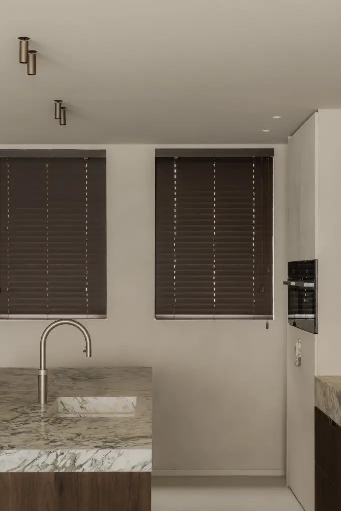 Kookeiland met spoelbak voor ramen met houten jaloezieën, Het Zoute Schorre, interieur Laura Calleeuw