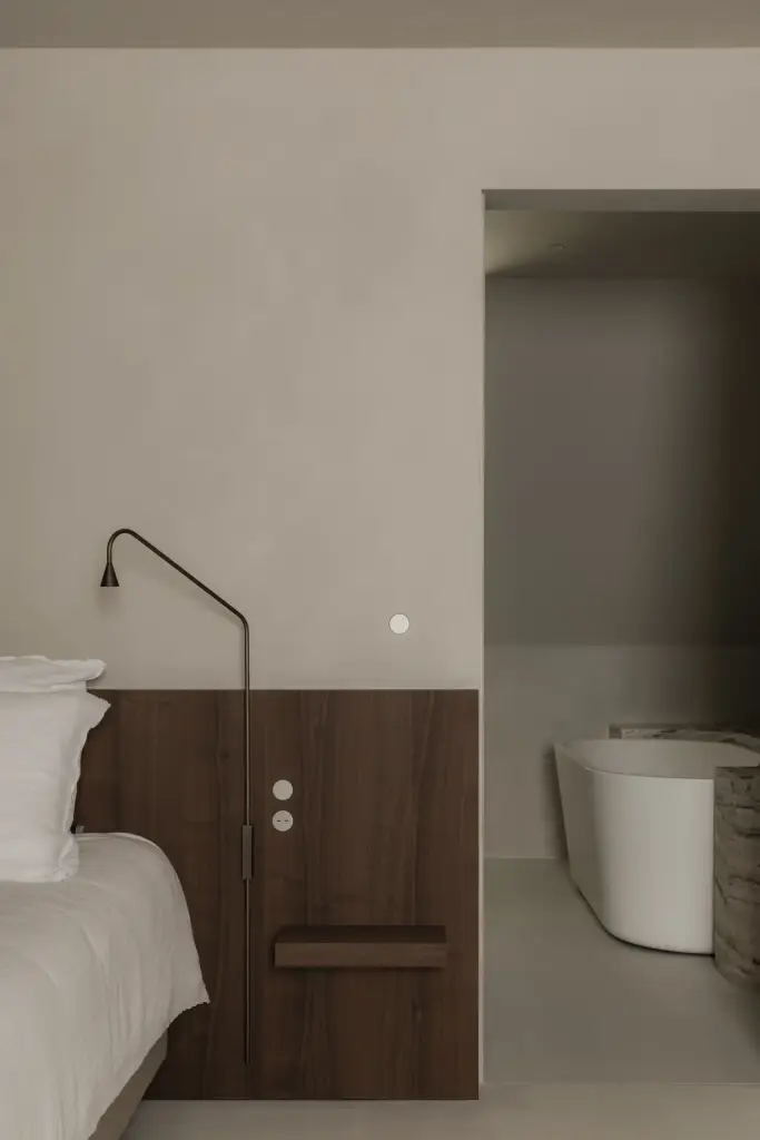 Slaapkamer met zicht op een vrijstaand bad door de open doorgang, Het Zoute Schorre, interieur Laura Calleeuw