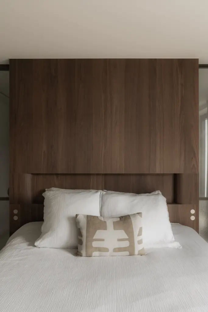 Detail van het houten hoofdbord met bed en kussens, Het Zoute Schorre, interieur Laura Calleeuw
