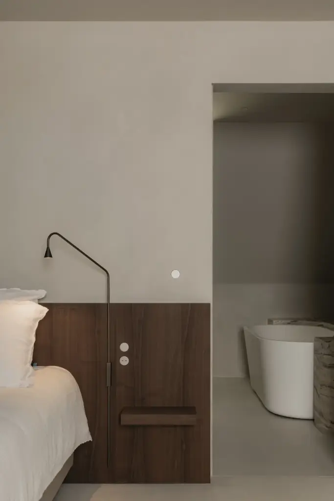 Bed en nachtkastje met zicht op de badkamer met vrijstaand bad, Het Zoute Schorre, interieur Laura Calleeuw