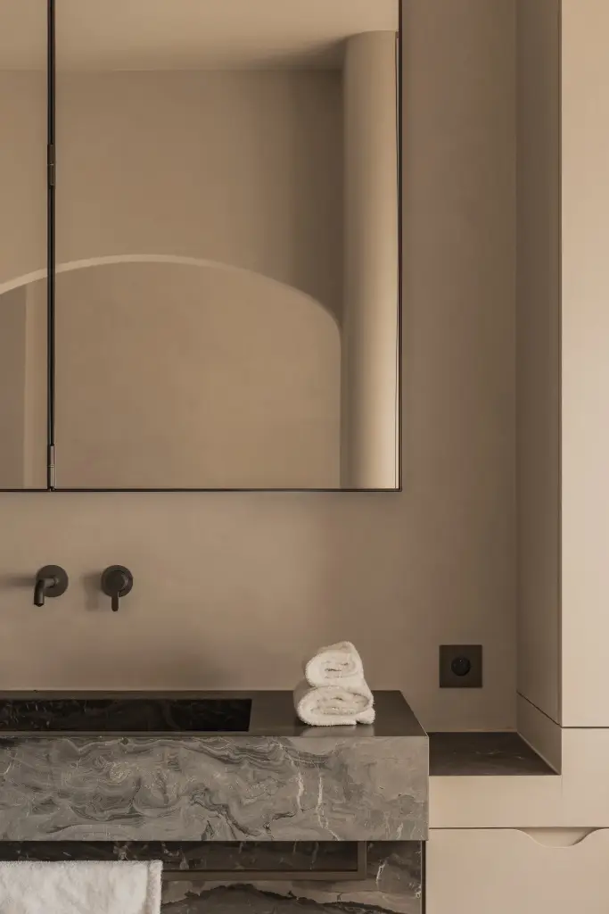 Badkamer met wastafel in marmer en spiegelkast in een boogvormige nis, Herenhuis in Brugge, interieur Laura Calleeuw