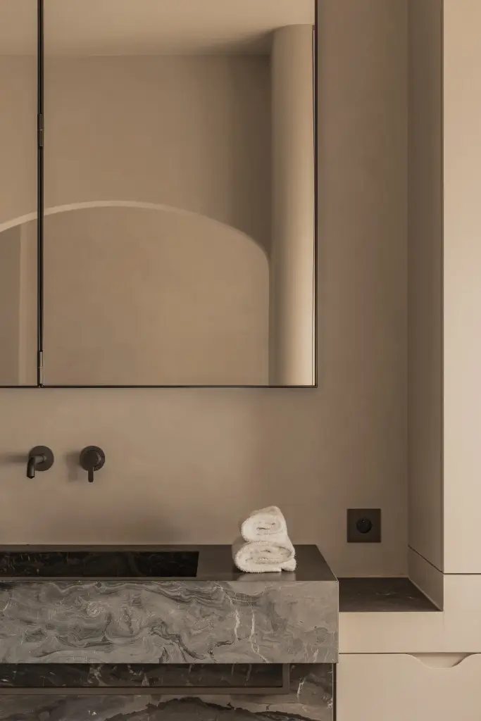 Badkamer met wastafel in marmer en spiegelkast in een boogvormige nis, Herenhuis in Brugge, interieur Laura Calleeuw