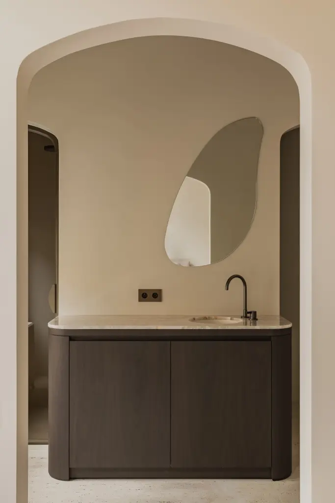 Wastafelmeubel met organische spiegel in een boogvormige nis, Herenhuis in Brugge, interieur Laura Calleeuw