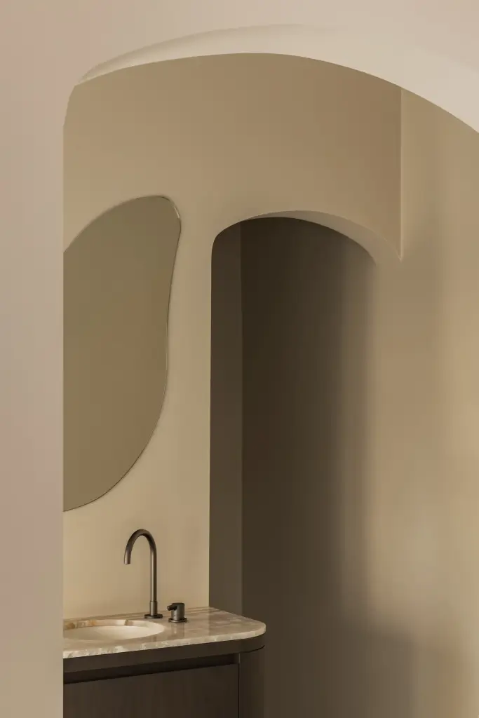 Wastafelmeubel met organische spiegel in een boogvormige nis, Herenhuis in Brugge, interieur Laura Calleeuw