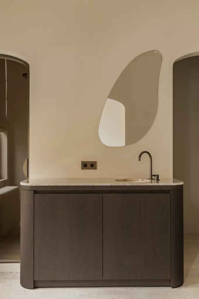 Wastafelmeubel met organische spiegel in een boogvormige nis, Herenhuis in Brugge, interieur Laura Calleeuw