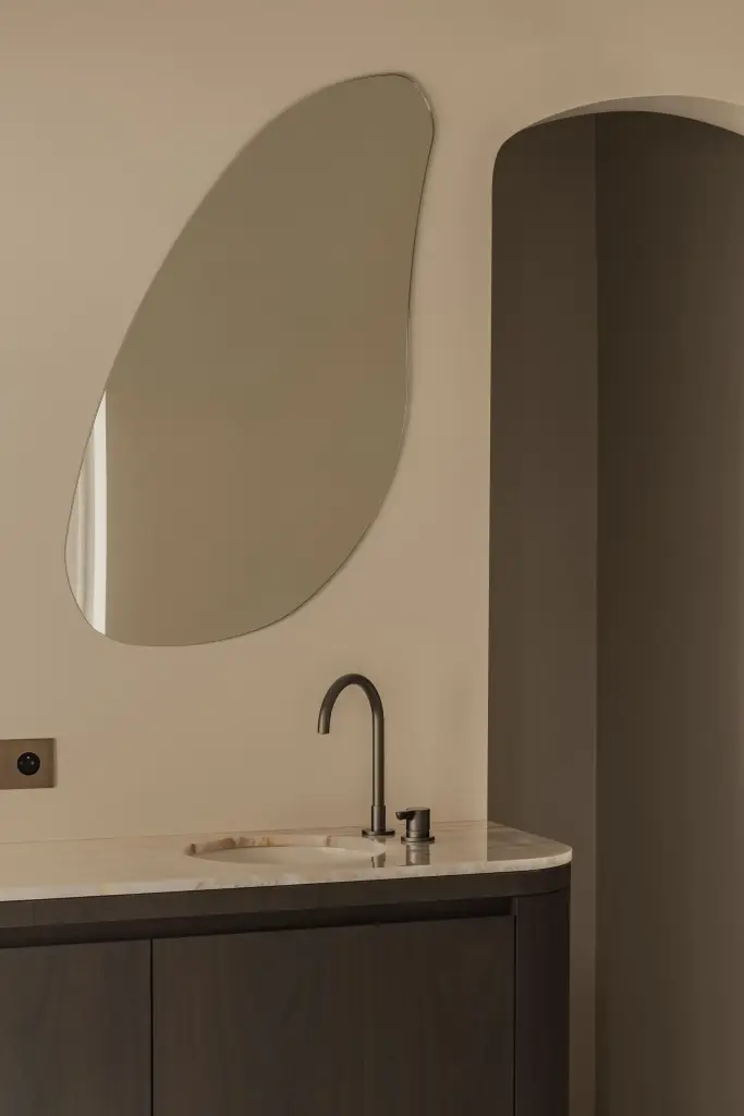 Wastafelmeubel met organische spiegel in een boogvormige nis, Herenhuis in Brugge, interieur Laura Calleeuw