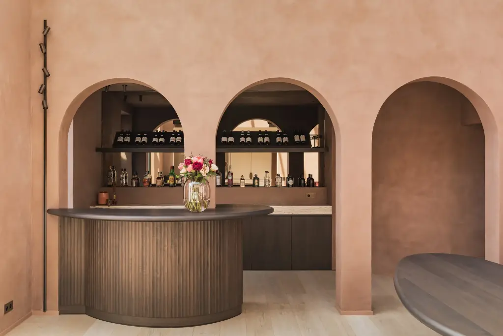 Ronde bar met lamellenfront en boogvormige nissen in terracotta kalkverf, Herenhuis in Brugge, interieur Laura Calleeuw