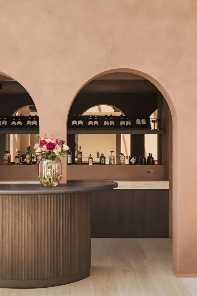 Ronde bar met lamellenfront en boogvormige nissen in terracotta kalkverf, Herenhuis in Brugge, interieur Laura Calleeuw
