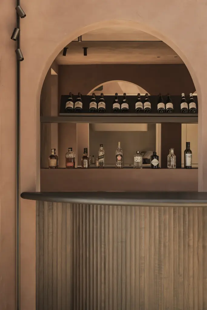 Boognis met flessen boven een bar met lamellenfront, Herenhuis in Brugge, interieur Laura Calleeuw