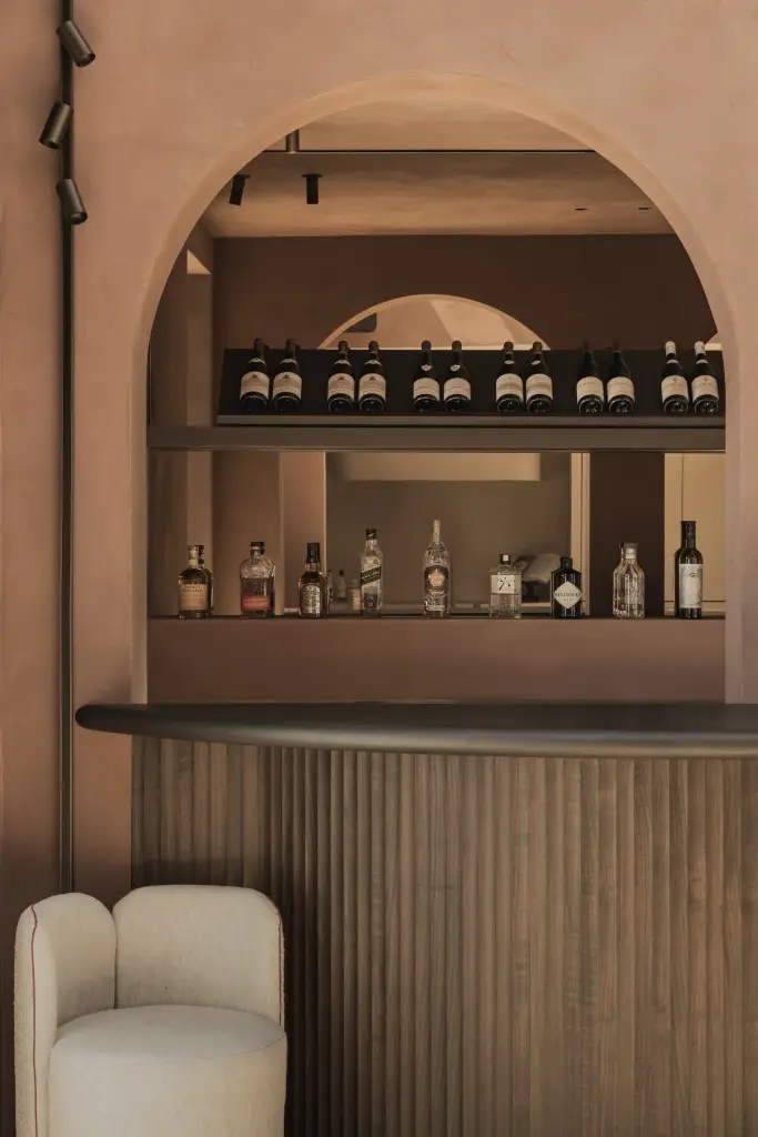 Boognis met flessen boven een bar met lamellenfront, Herenhuis in Brugge, interieur Laura Calleeuw