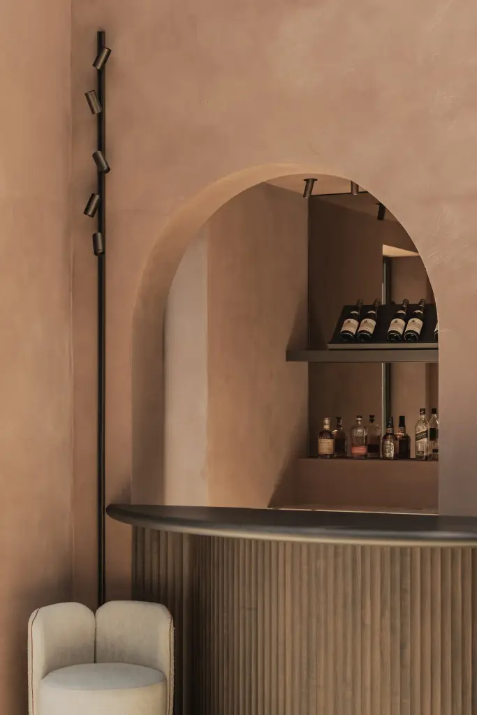 Boognis met flessen boven een bar met lamellenfront, Herenhuis in Brugge, interieur Laura Calleeuw