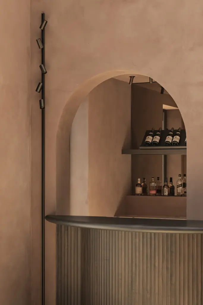 Boognis met flessen boven een bar met lamellenfront, Herenhuis in Brugge, interieur Laura Calleeuw