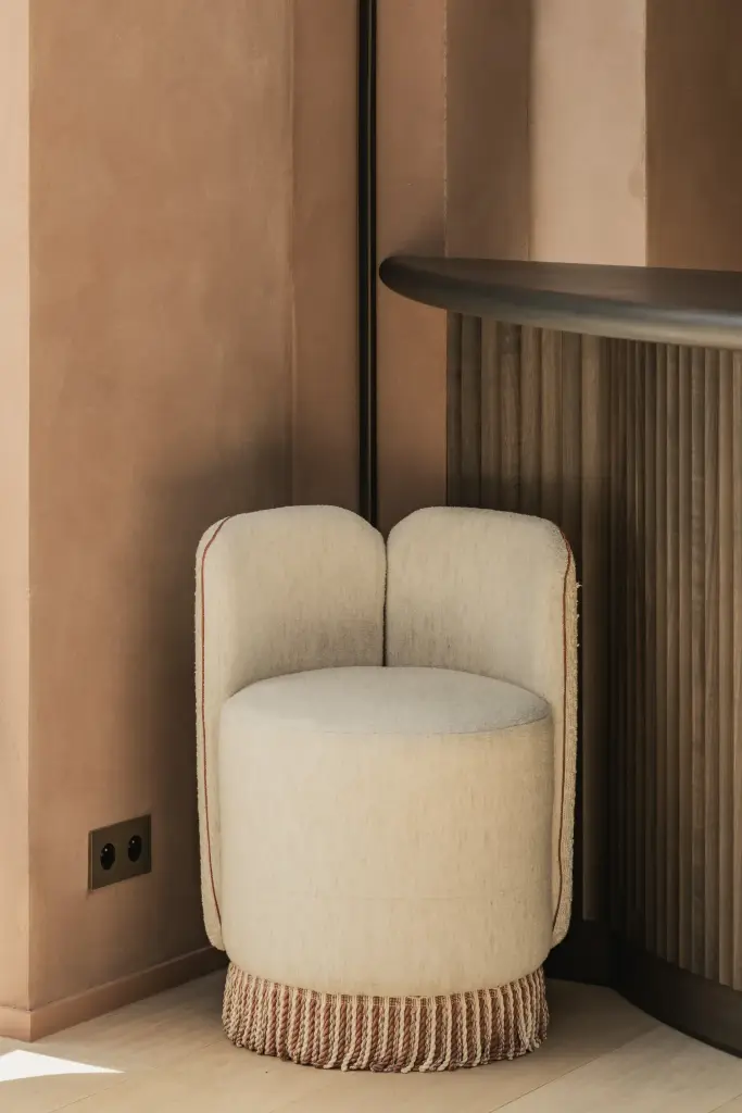 Bouclé fauteuil met franjes naast de lamellenbar, Herenhuis in Brugge, interieur Laura Calleeuw