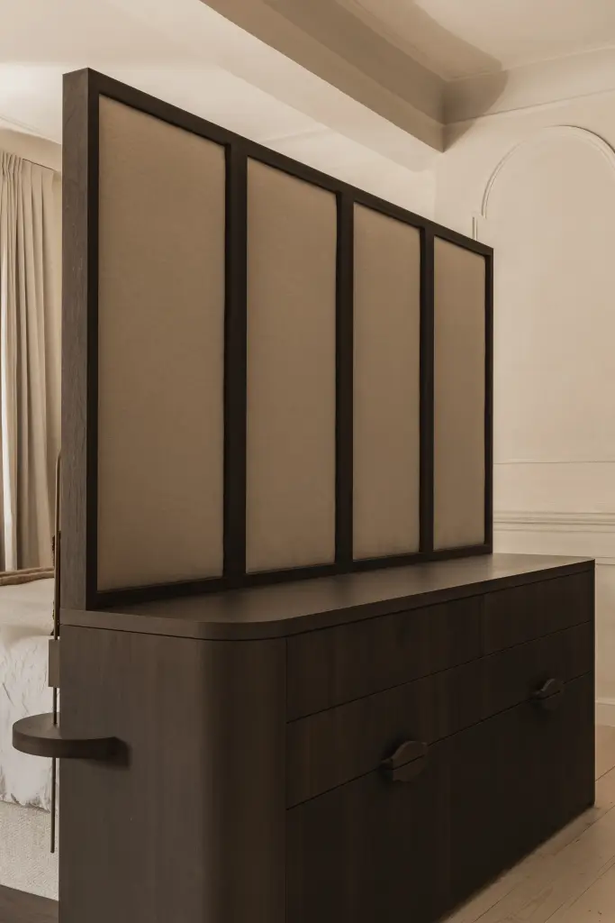 Commode in donker hout voor een gestoffeerd paneel in de slaapkamer, Herenhuis in Brugge, interieur Laura Calleeuw