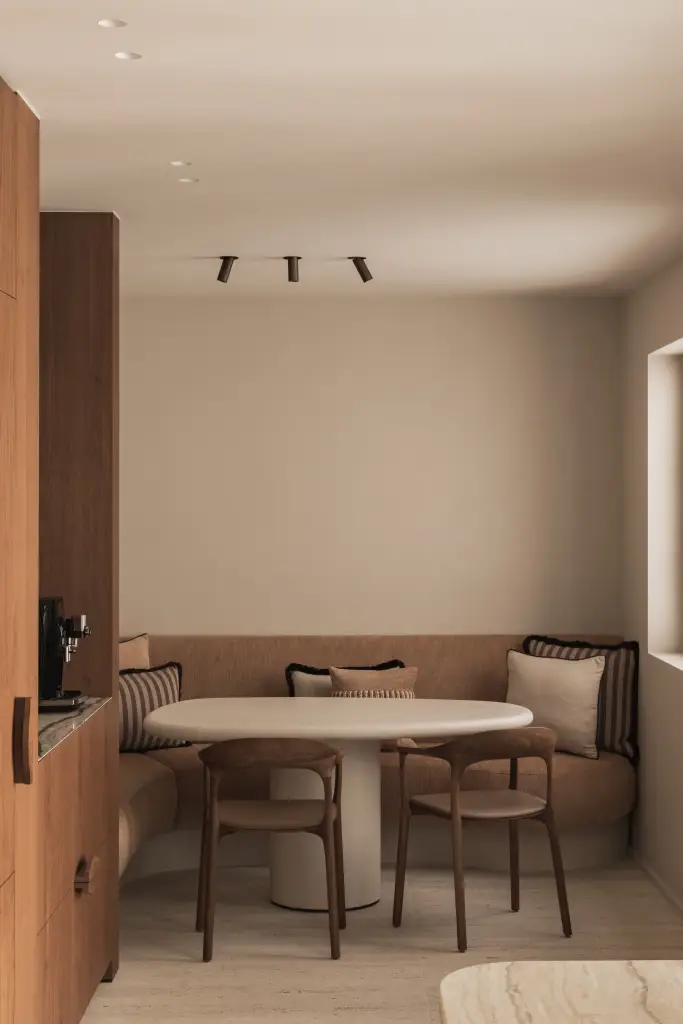 Eethoek met ronde tafel, houten stoelen en zitbank naast de keuken, Herenhuis in Brugge, interieur Laura Calleeuw