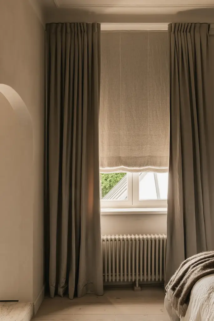 Zware gordijnen en rolgordijn voor het slaapkamerraam, Herenhuis in Brugge, interieur Laura Calleeuw