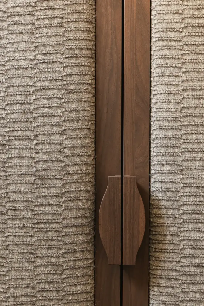 Detail van een walnoten handgreep op een gestoffeerde kastdeur, Herenhuis in Brugge, interieur Laura Calleeuw