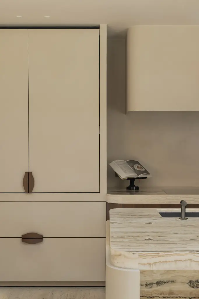 Keukenkastenwand in crème met walnoten handgrepen en onyx werkblad, Herenhuis in Brugge, interieur Laura Calleeuw