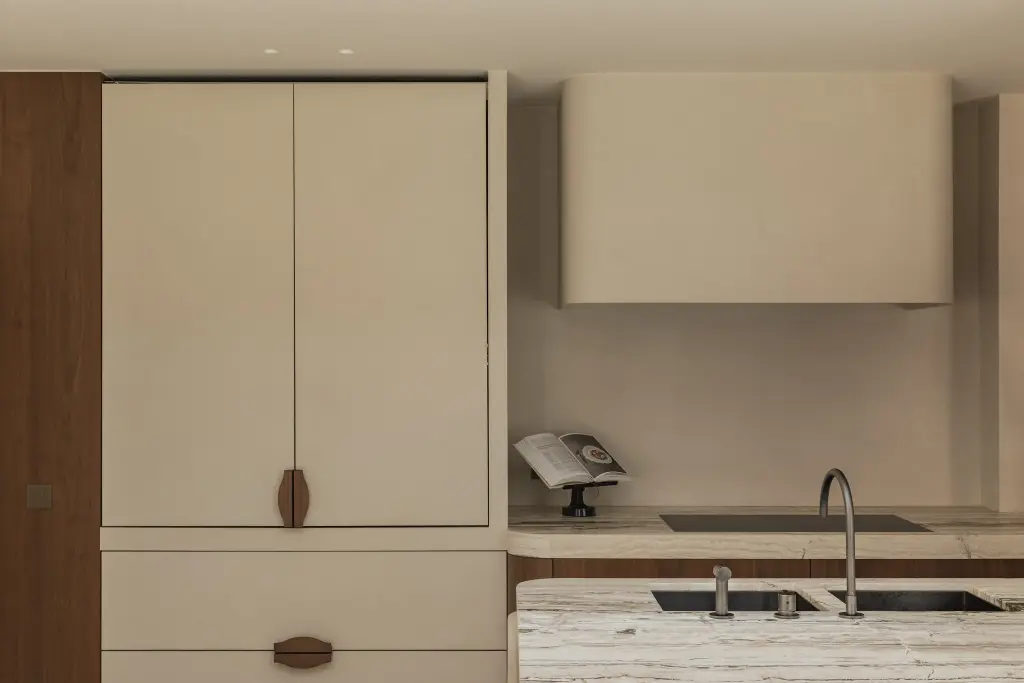 Keukenkastenwand in crème met walnoten handgrepen en onyx werkblad, Herenhuis in Brugge, interieur Laura Calleeuw