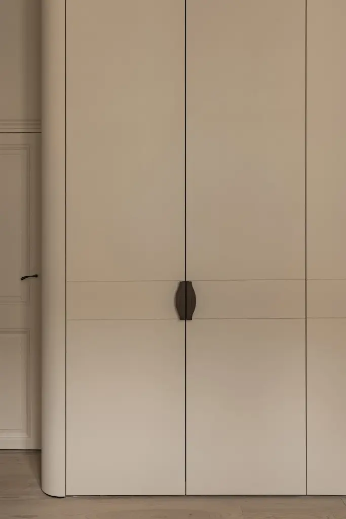 Kleerkasten in crème met gebogen hoek en bronzen handgrepen, Herenhuis in Brugge, interieur Laura Calleeuw