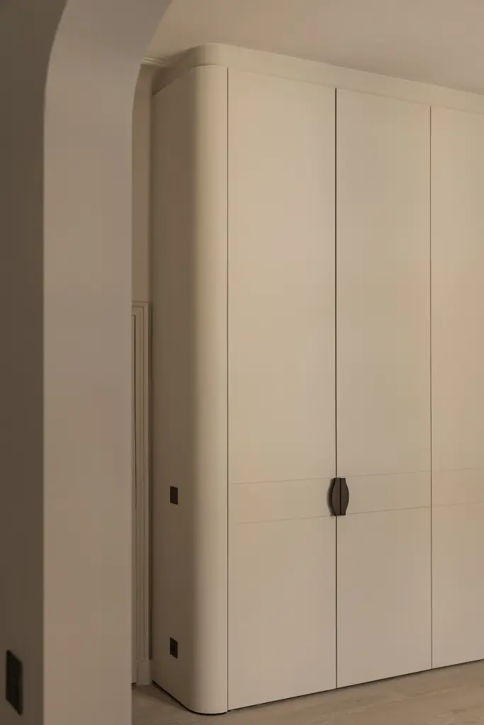 Kleerkasten in crème met gebogen hoek en bronzen handgrepen, Herenhuis in Brugge, interieur Laura Calleeuw