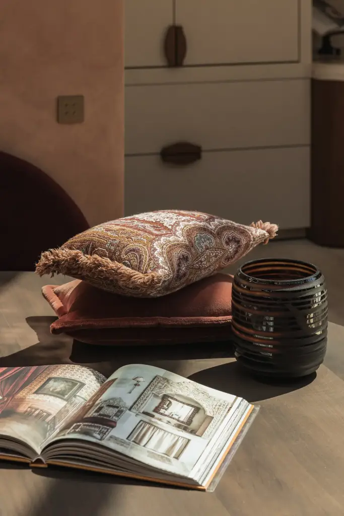 Kussens, interieurboek en vaas op de eettafel, Herenhuis in Brugge, interieur Laura Calleeuw