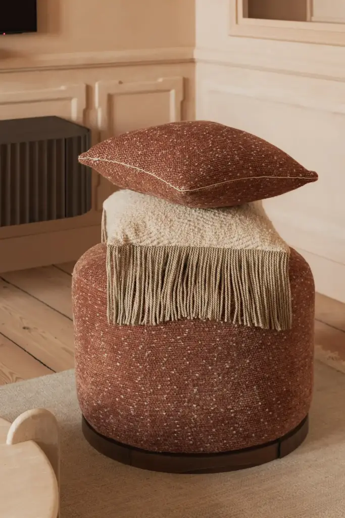 Poef in roestkleurige bouclé met plaid en kussen, Herenhuis in Brugge, interieur Laura Calleeuw