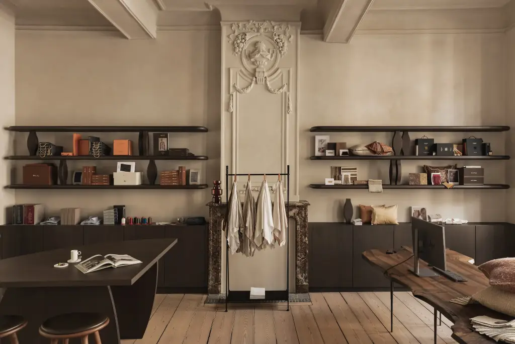 Showroom in herenhuis met marmeren schouw, stucwerk ornament en zwevende planken, Herenhuis in Brugge, interieur Laura Calleeuw