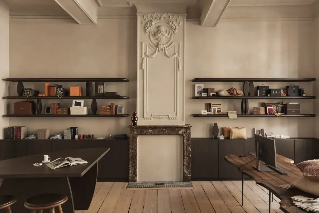 Showroom in herenhuis met marmeren schouw, stucwerk ornament en zwevende planken, Herenhuis in Brugge, interieur Laura Calleeuw