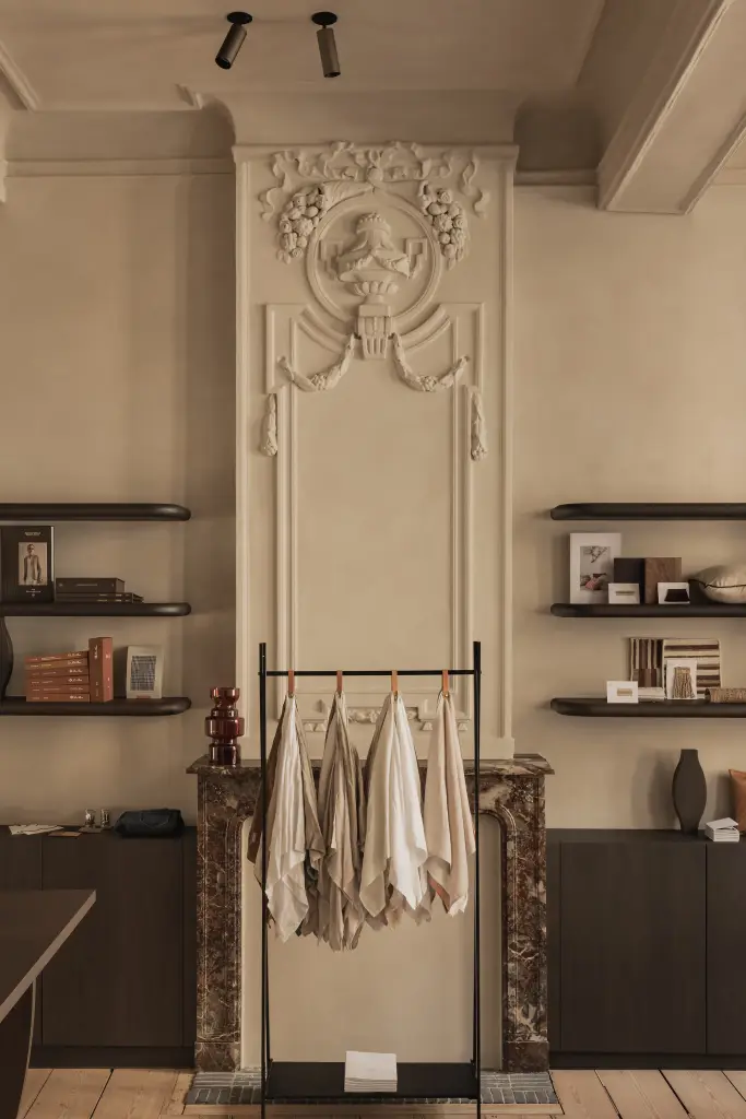 Showroom in herenhuis met marmeren schouw, stucwerk ornament en zwevende planken, Herenhuis in Brugge, interieur Laura Calleeuw