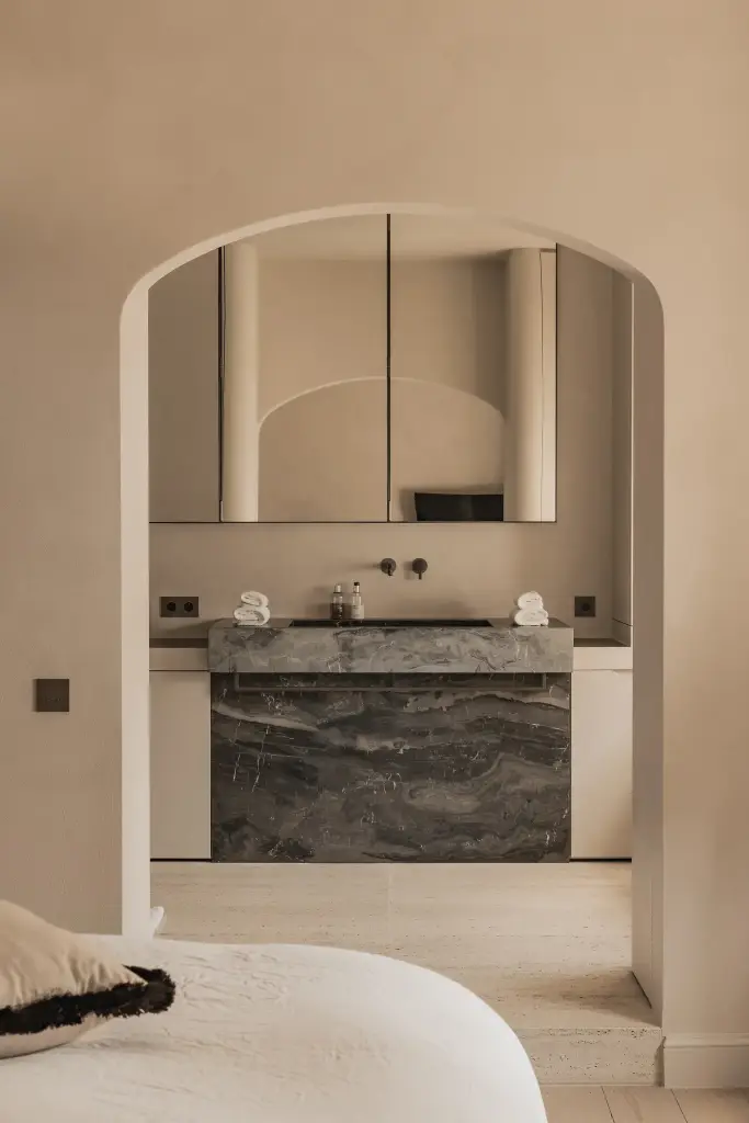 Slaapkamer met boogvormige doorgang naar de badkamer met marmeren wastafel, Herenhuis in Brugge, interieur Laura Calleeuw
