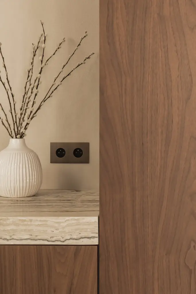 Vaas met takken, stopcontact en onyx werkblad naast walnoten kolom, Herenhuis in Brugge, interieur Laura Calleeuw