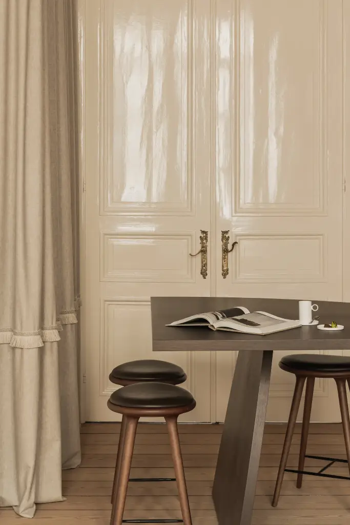 Werktafel met barkrukken, linnen gordijn en glanzende dubbele deur, Herenhuis in Brugge, interieur Laura Calleeuw