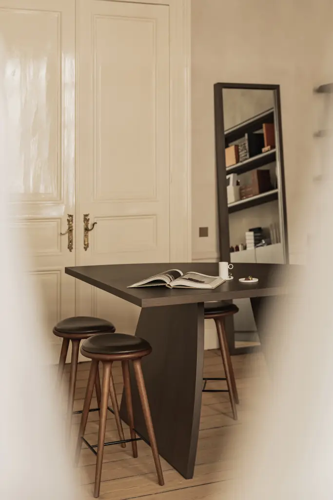 Werktafel met barkrukken, linnen gordijn en glanzende dubbele deur, Herenhuis in Brugge, interieur Laura Calleeuw