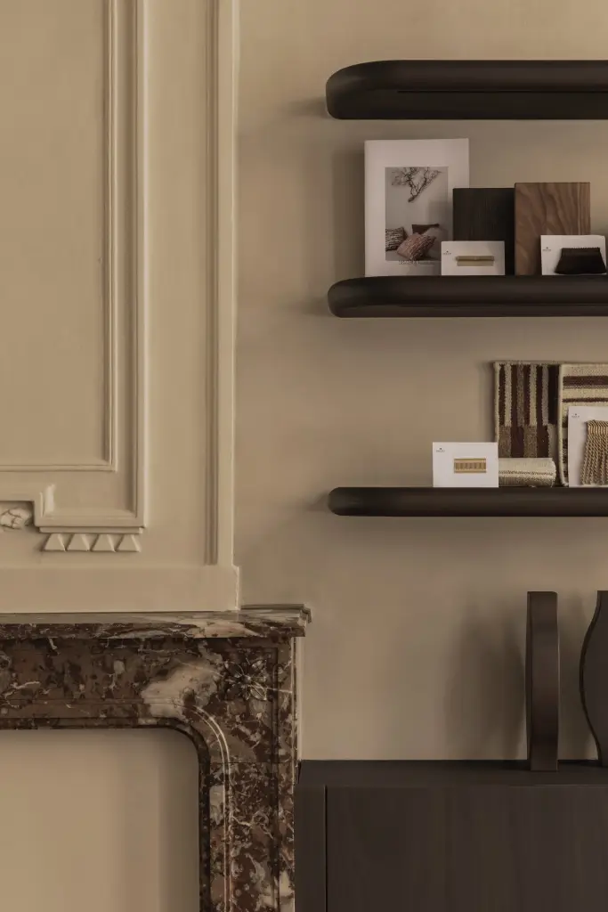 Zwevende donkere planken met stalen en accessoires boven een marmeren schouw, Herenhuis in Brugge, interieur Laura Calleeuw