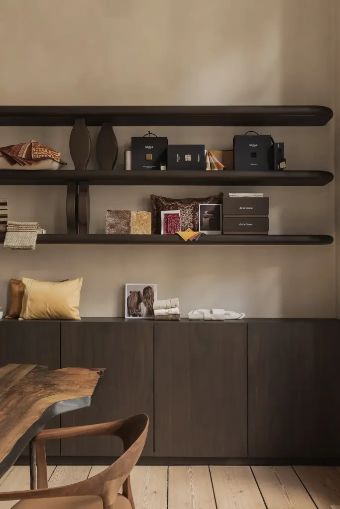 Zwevende donkere planken met stalen en accessoires boven een marmeren schouw, Herenhuis in Brugge, interieur Laura Calleeuw