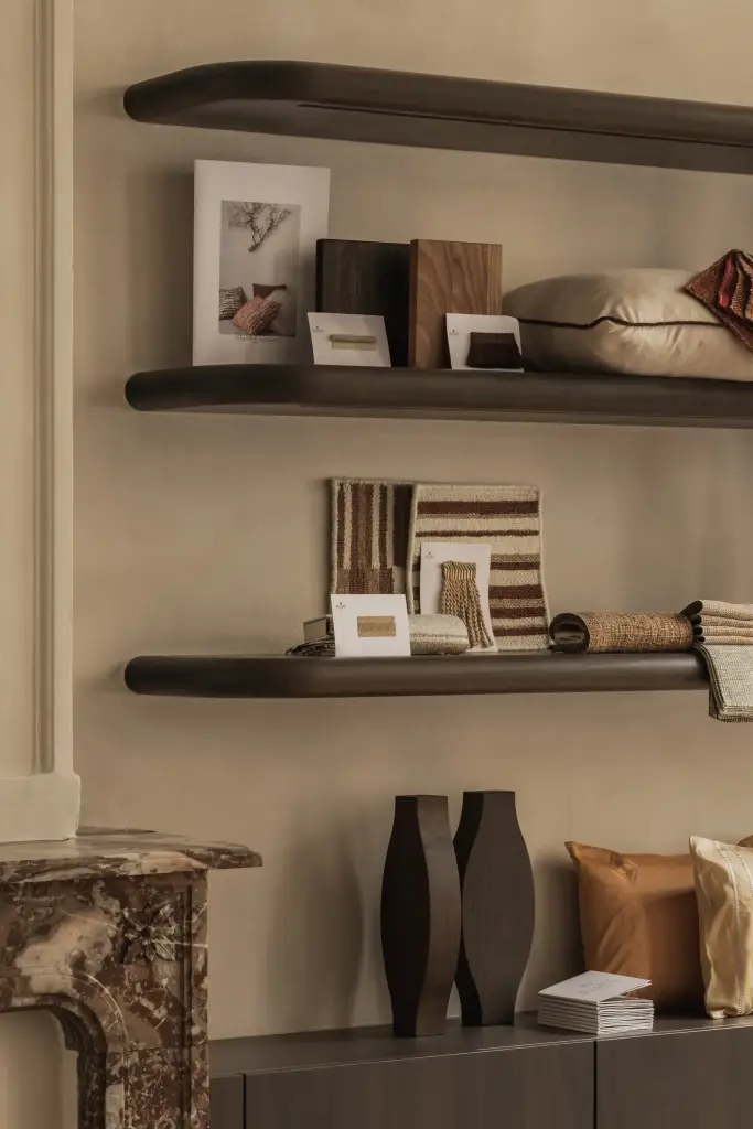 Zwevende donkere planken met stalen en accessoires boven een marmeren schouw, Herenhuis in Brugge, interieur Laura Calleeuw