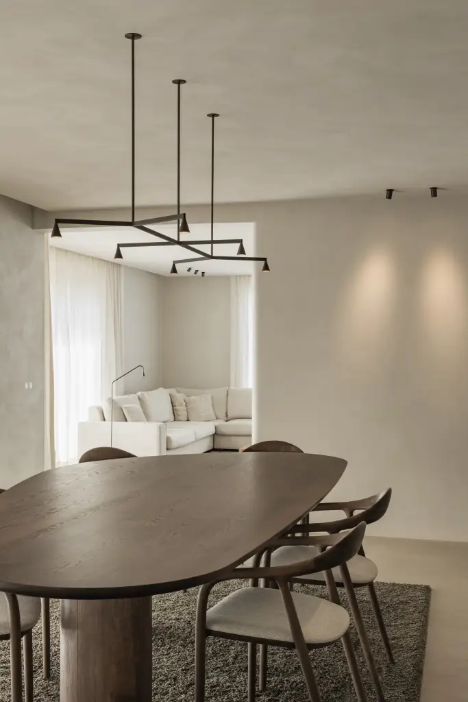 Eethoek met ovale tafel, zwarte hanglamp en doorkijk naar de hoekzetel, Villa in Loppem, interieur Laura Calleeuw