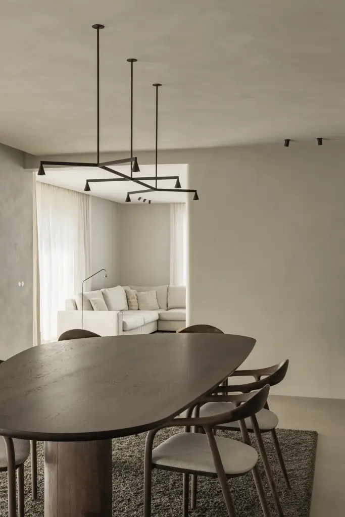 Eethoek met ovale tafel, zwarte hanglamp en doorkijk naar de hoekzetel, Villa in Loppem, interieur Laura Calleeuw