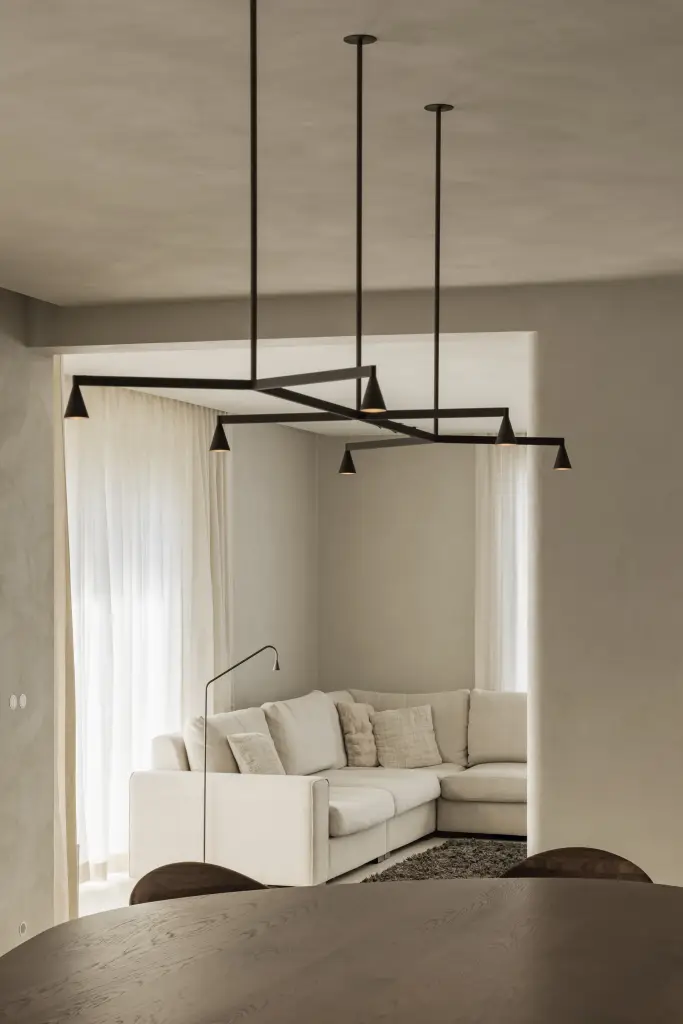 Eethoek met ovale tafel, zwarte hanglamp en doorkijk naar de hoekzetel, Villa in Loppem, interieur Laura Calleeuw