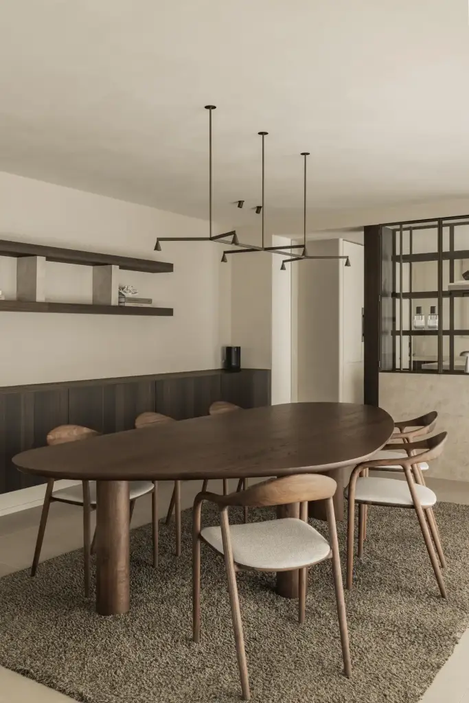 Eethoek met ovale notenhouten tafel, hanglamp en zwevende wandplanken, Villa in Loppem, interieur Laura Calleeuw