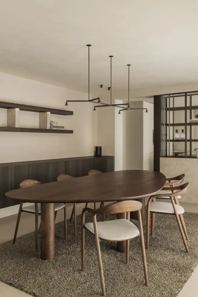 Eethoek met ovale notenhouten tafel, hanglamp en zwevende wandplanken, Villa in Loppem, interieur Laura Calleeuw
