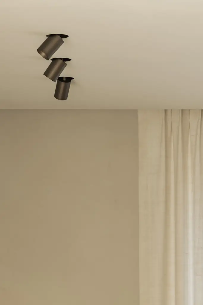 Zwarte inbouwspots naast een linnen gordijn, Villa in Loppem, interieur Laura Calleeuw