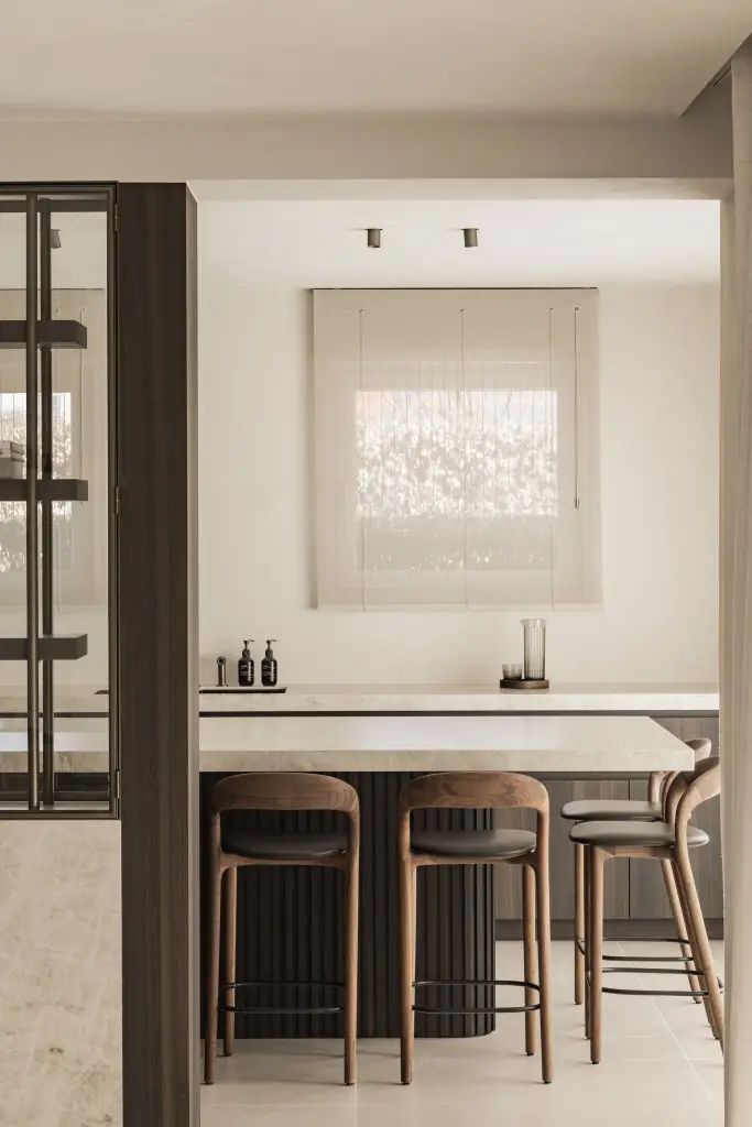 Keukeneiland met barkrukken en een raam met geplooid rolgordijn, Villa in Loppem, interieur Laura Calleeuw