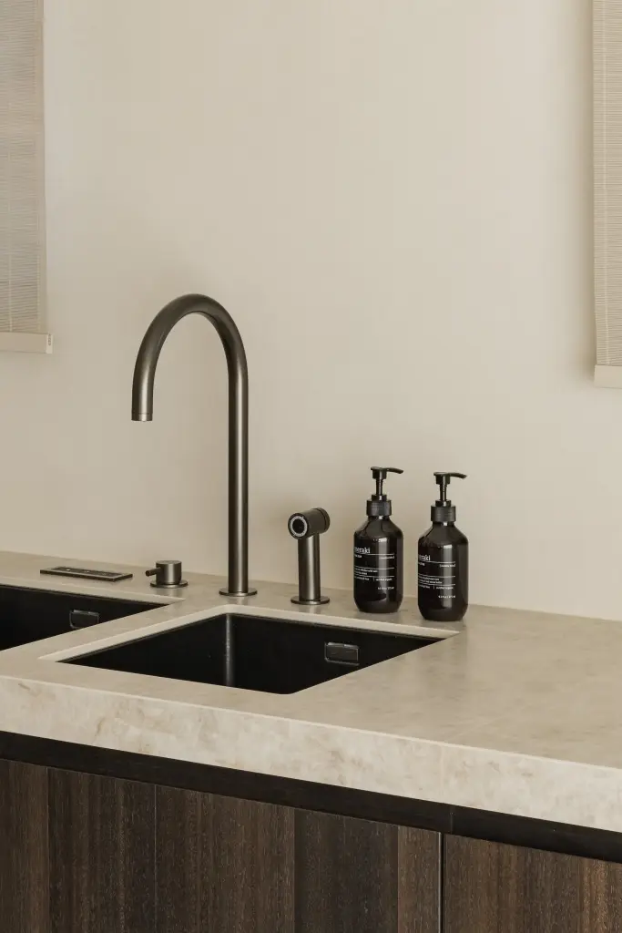 Messing keukenkraan en spoelbak in natuursteen werkblad, Villa in Loppem, interieur Laura Calleeuw
