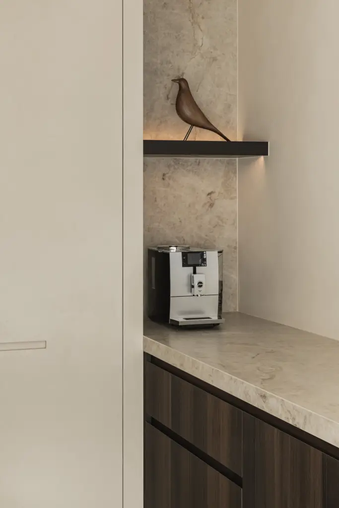 Koffiehoek met houten vogeltje op een plank voor natuursteen, Villa in Loppem, interieur Laura Calleeuw